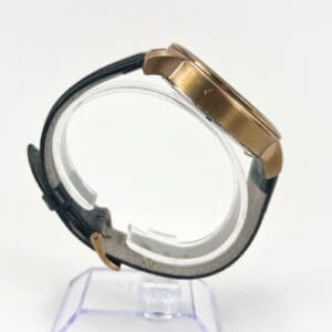 Side view of a wristwatch with leather strap.