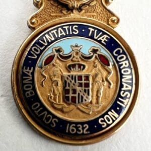 Gold emblem with Latin inscription and crest.
