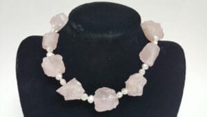 Rose quartz and pearl necklace on display.
