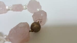 Pink stone necklace with pearl accents.