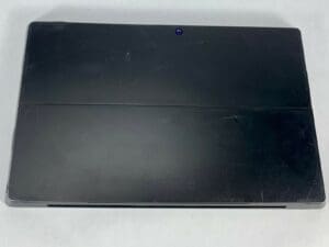 Closed black laptop on white surface.