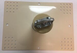 Metallic knob on rectangular beige panel.