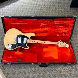 Electric guitar in red velvet-lined case.