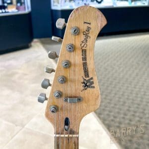 Wooden guitar headstock with tuning pegs.