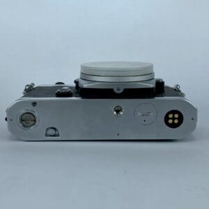 Bottom view of vintage camera with lens cap.