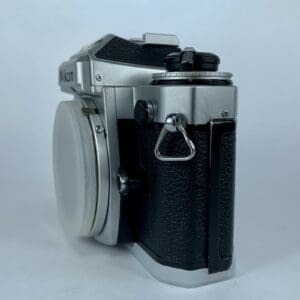 Silver vintage camera with black grip, side view.