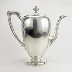Silver teapot with ornate handle and spout.