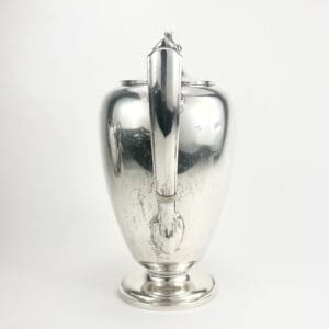 Silver teapot with a curved handle.