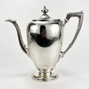 Silver teapot with ornate handle and spout.