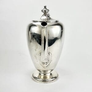 Silver teapot with ornate lid and spout.