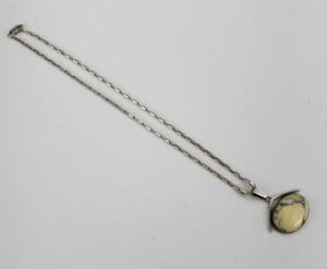 Silver necklace with oval pendant stone.