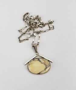 Silver chain with oval stone pendant.