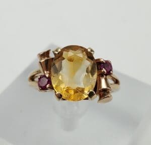 Gold ring with yellow and red gemstones.