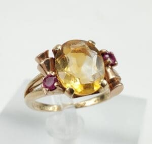 Gold ring with yellow and pink gemstones.