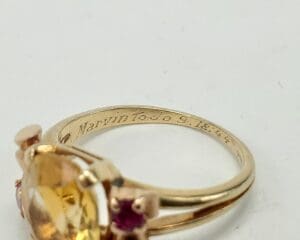 Gold ring with gemstones and engraved inscription.