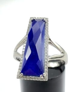 Silver ring with large blue rectangular gemstone.