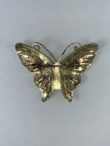 Gold butterfly brooch with intricate details.