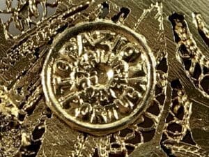 Gold textured surface with circular emblem.