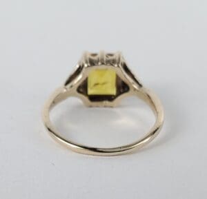 Gold ring with square yellow gemstone.