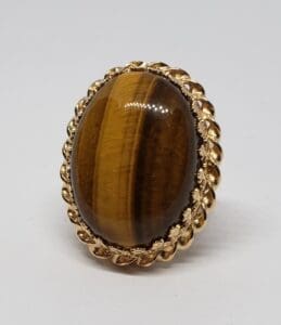 Gold ring with oval brown gemstone.