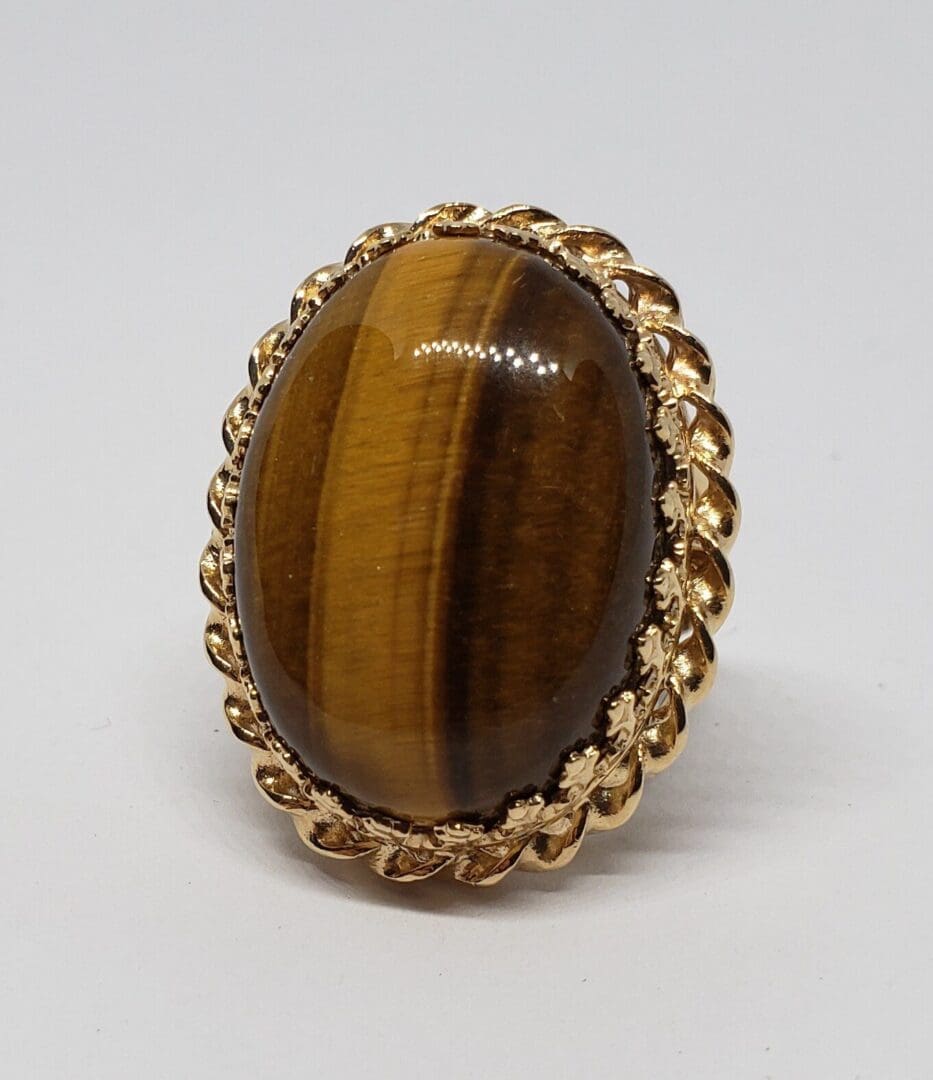 Gold ring with oval brown gemstone.