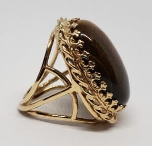Gold ring with large brown gemstone.