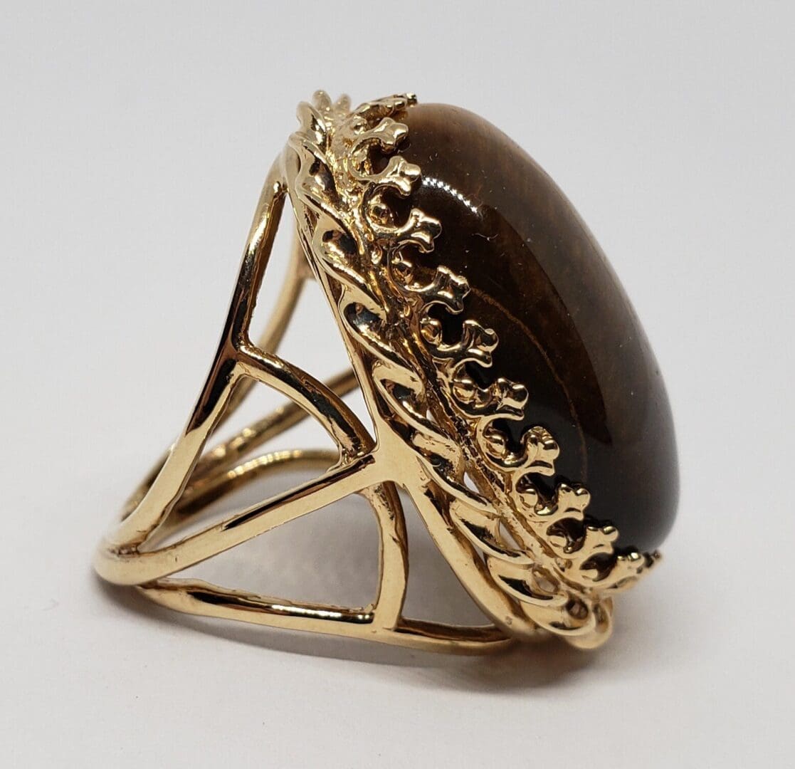 Gold ring with large brown gemstone.