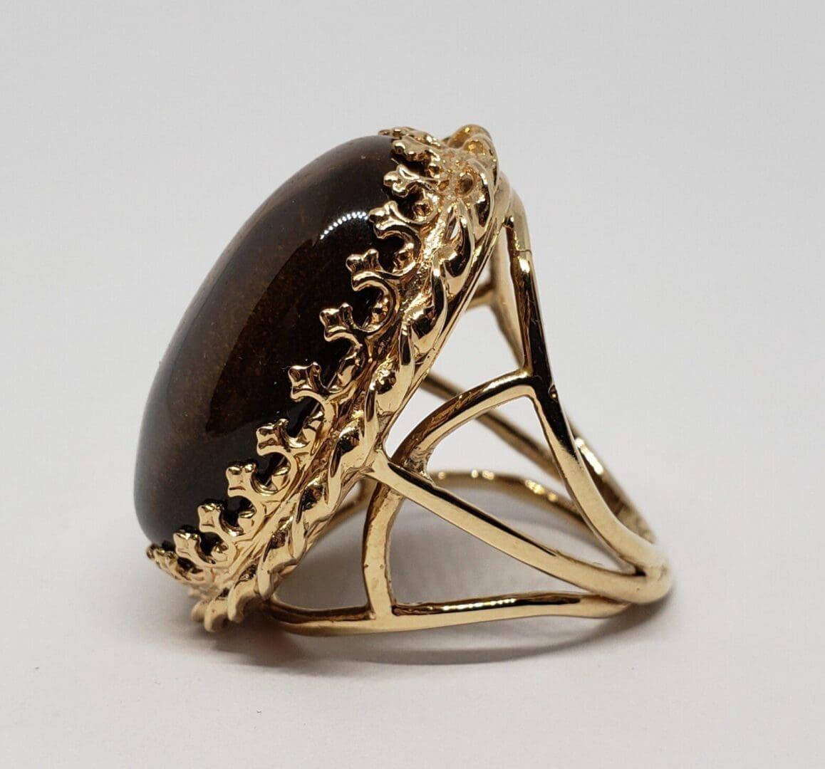 Gold ring with large dark gemstone.