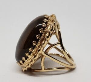 Gold ring with large dark gemstone.
