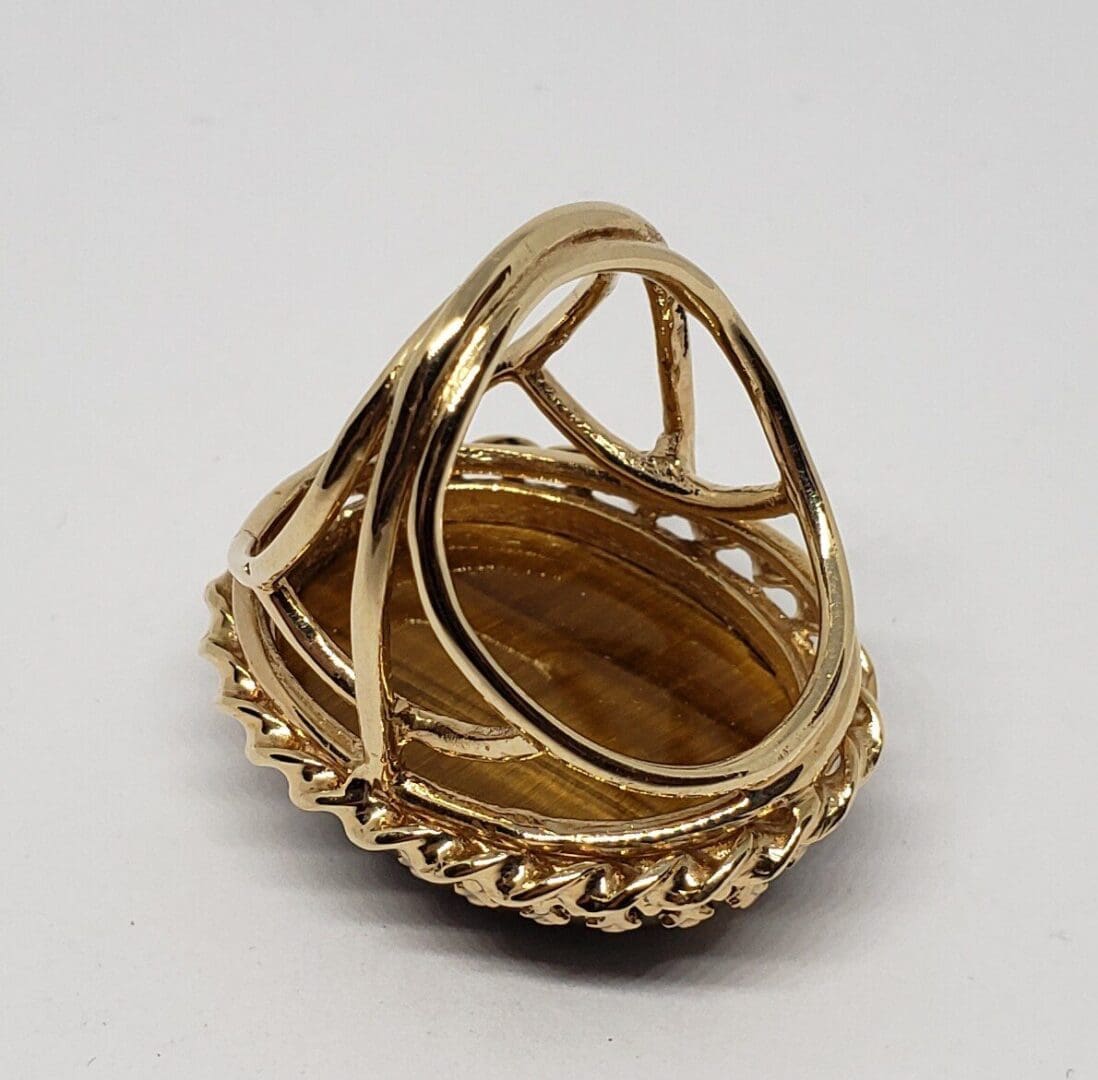 Gold ring with an oval brown stone.