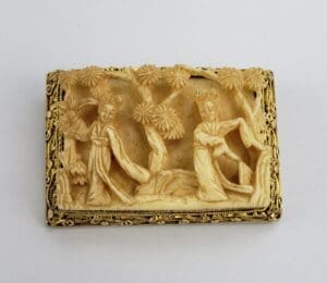 Intricate carved scene with figures and trees.