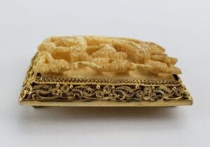 Ornate carved object with intricate gold detailing.