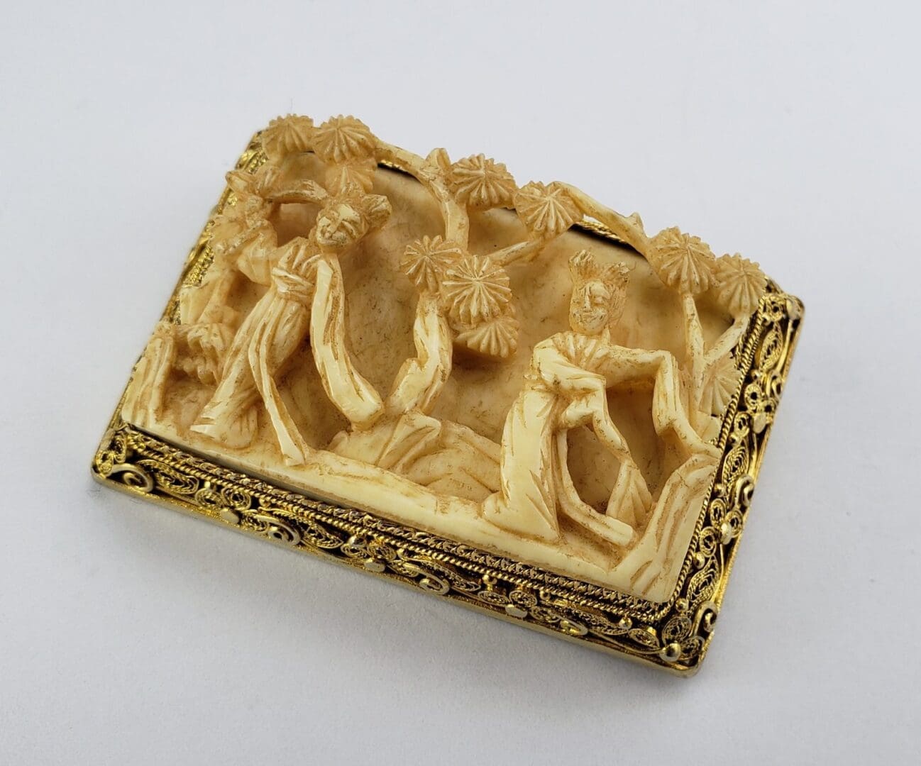 Intricately carved ivory plaque with figures.