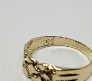 Gold ring with "OK" engraved inside.