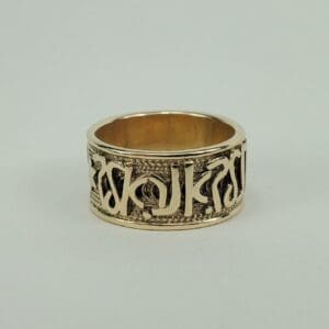 Gold ring with intricate engraved design.