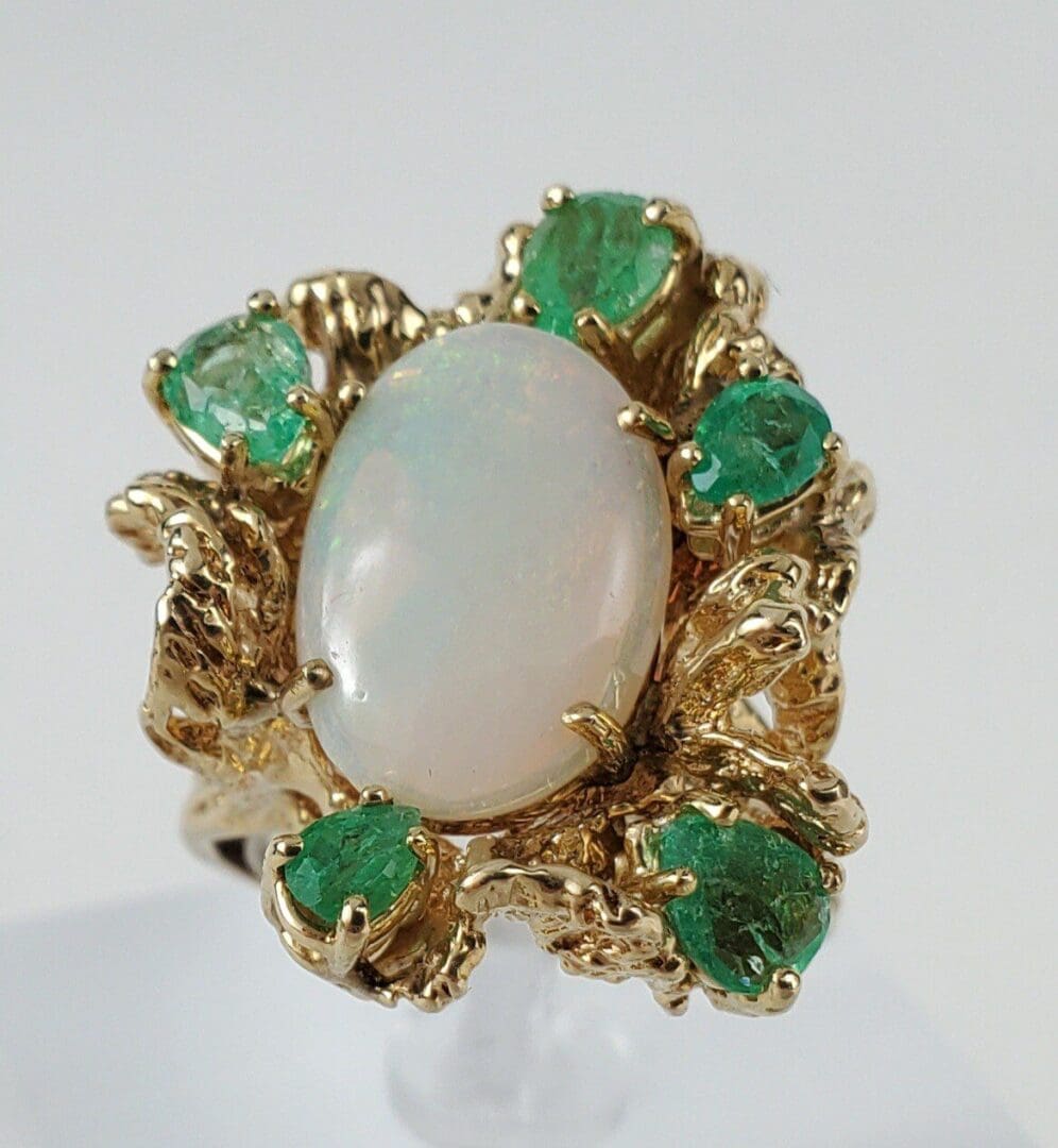 Gold ring with opal and green stones.