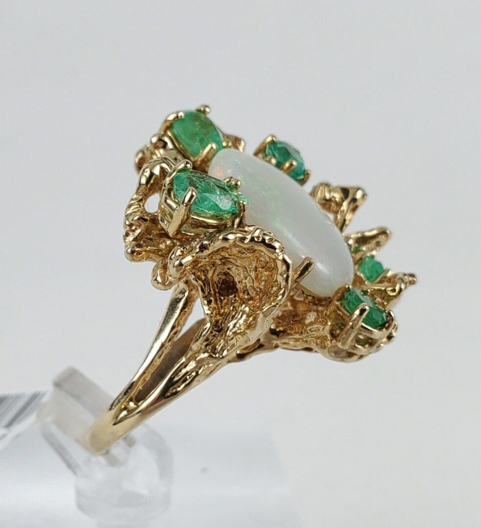 Gold ring with opal and emerald stones.