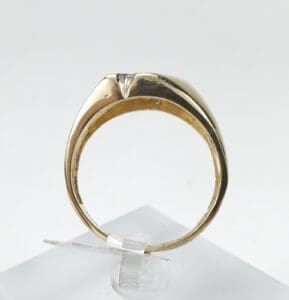 Gold ring displayed on a stand.