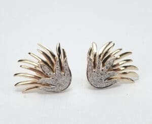Gold and silver wing-shaped earrings.