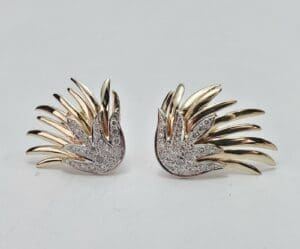 Gold and silver wing-shaped earrings.