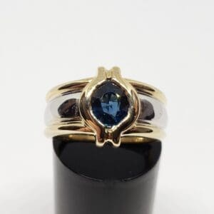 Gold ring with blue gemstone on display.