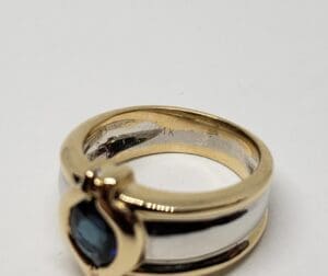 Gold and silver ring with blue gemstone.