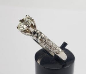Diamond engagement ring on display stand.