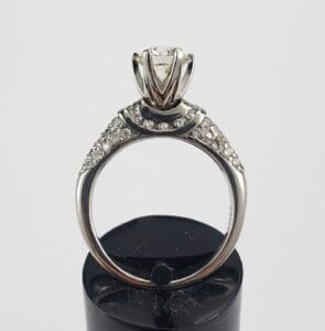 Diamond ring with intricate detailing displayed upright.