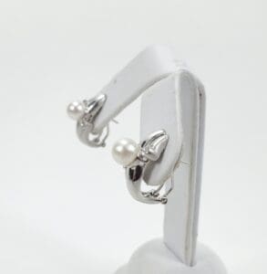 Silver earrings with pearl accents displayed.