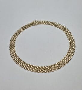 Gold chain necklace on white background.