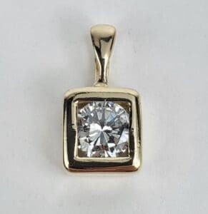 Gold pendant with large round diamond.