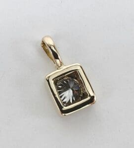 Gold pendant with square gemstone design.