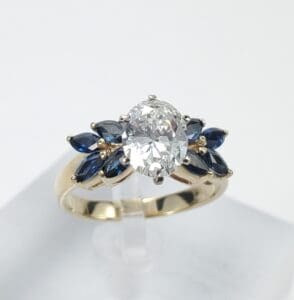 Gold ring with diamond and blue gemstones.