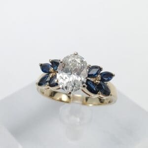 Gold ring with diamond and blue stones.
